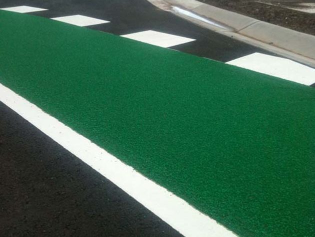 A green anti-skid cycle lane beside a white edge line and kerb