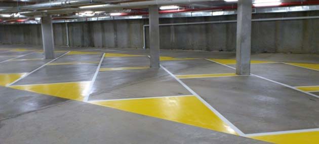 Yellow hatched no-parking areas and white lines on the floor of an underground car park